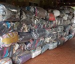 60 Paquetes de ropa embalada de 30 kg cada uno y de unos 0,8x0,35x0,40 metros cada paquete